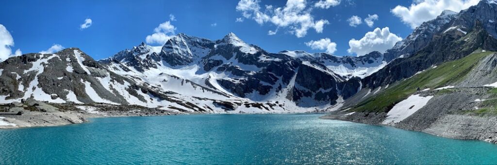 snow covered mountain near body of water during daytime